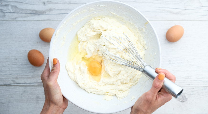 Рецепт теста сливками. Добавляем яйца по одному в тесто.