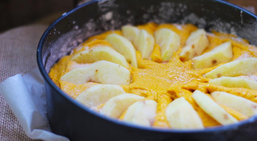 Выложить тесто в форму, уложить поверх яблоки, выпекать до готовности