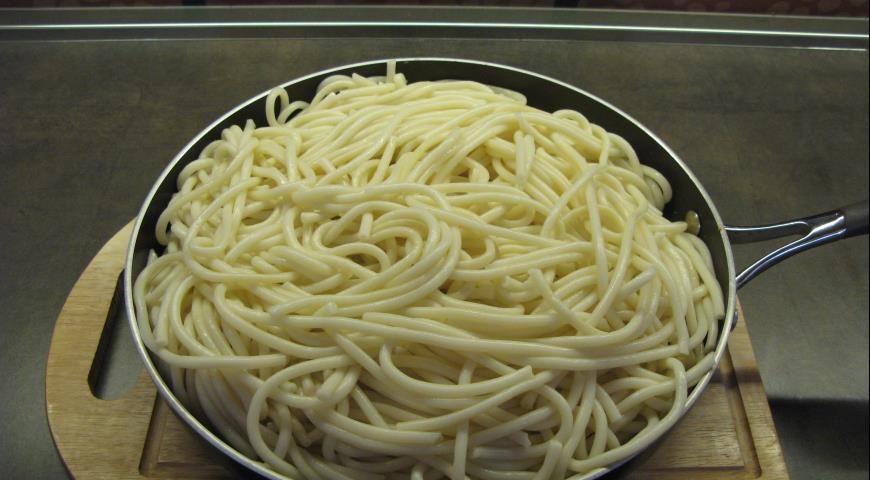 Выложить на обжаренные ингредиенты отваренные спагетти