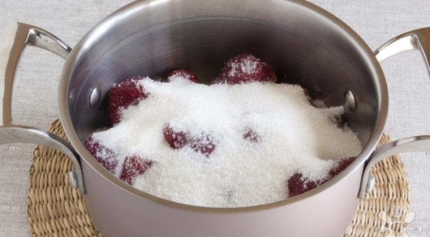 Добавляем сахар к клубнике для приготовления варенья с мятой и базиликом