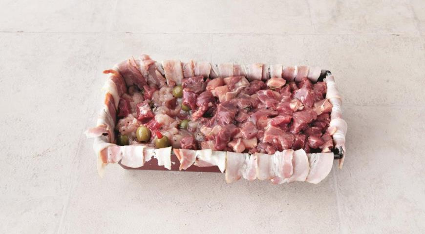 На дно формы выложите половину смеси из свинины и телятины,