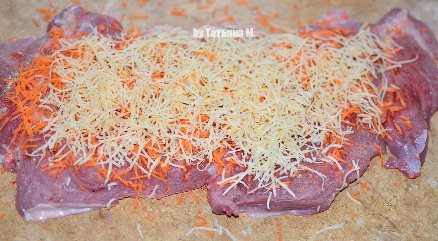 Посыпаем мясо для рулета тертыми морковью и сыром