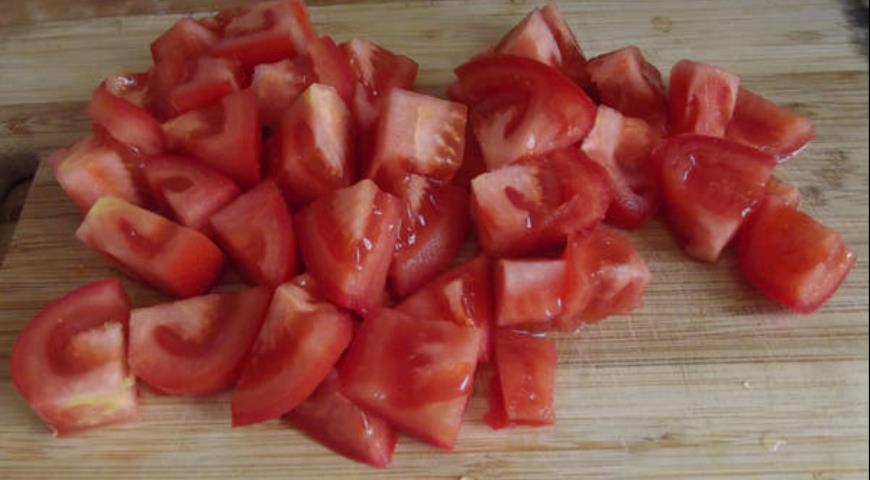 Нарезать кубиками помидоры для добавления в салат