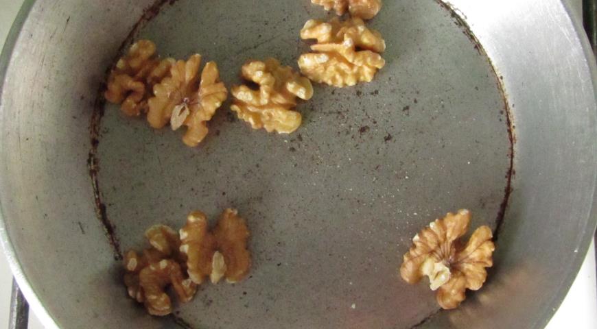 Прокалить грецкие орехи, затем очистить и порубить 
