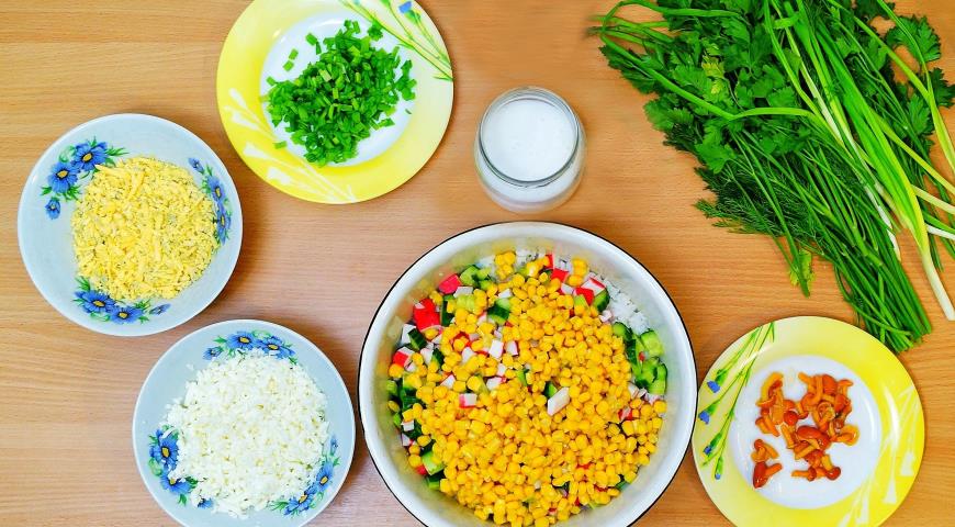 Выкладываем в салатник отварной рис, крабовые палочки, огурец и кукурузу