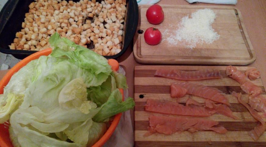 Салатные листья порвать, нарезать помидоры и лосось, сделать гренки