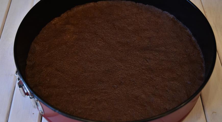 Измельченное шоколадное печенье смешть со сливочным маслом, выложить крошку в форму, примять