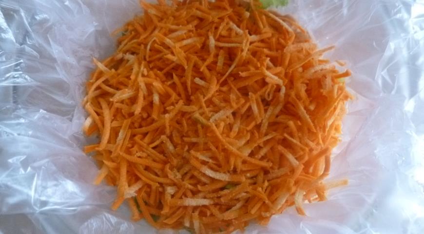 Выкладываем на пленку слой моркови, кукурузы, салатных листьев и креветок