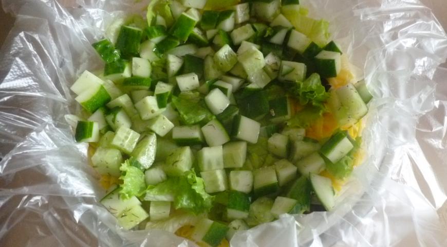 Сверху выкладываем огурцы и убираем слоеный овощной салат в холодильник на 2 часа