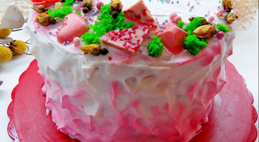Украшаем торт-рулет взбитыми сливками, часть из которых окрашиваем розовым красителем