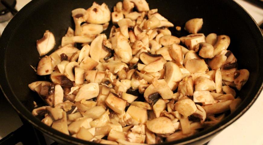 Добавить грибы, петрушку и специи, обжаривать начинку до готовности